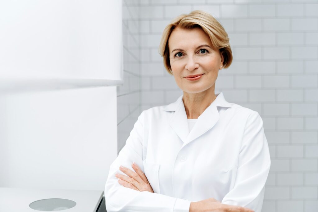 Welcome to our beauty salon. Portrait of mature cosmetologist in white lab coat